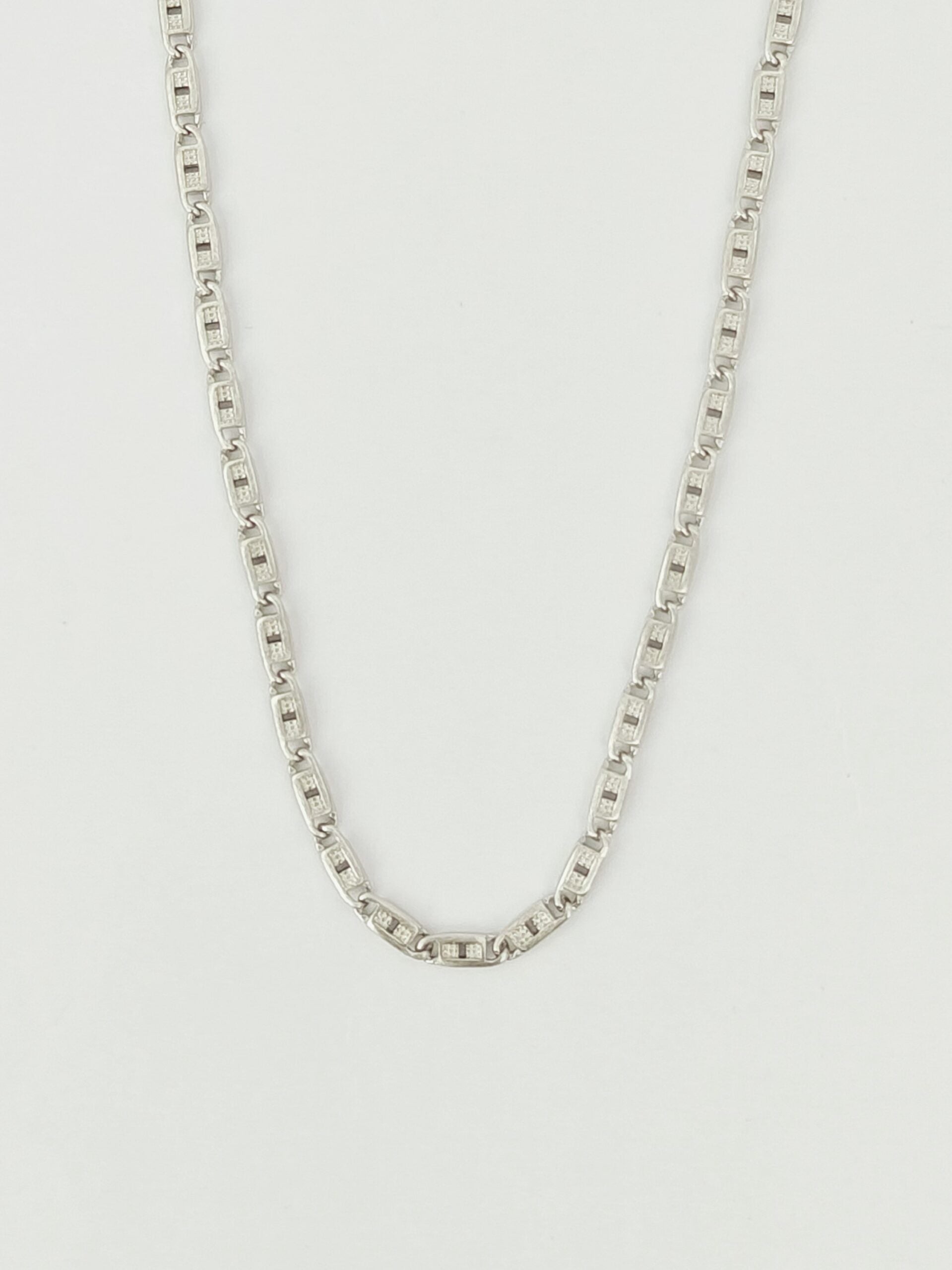 Silver chain necklace on a light gray background